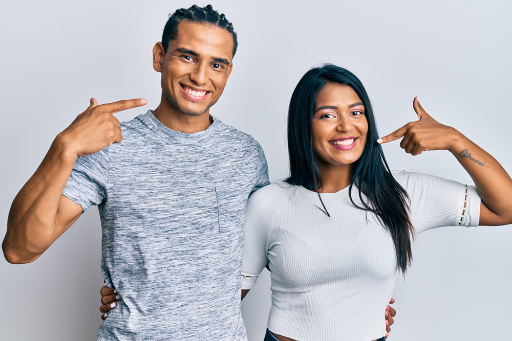 Couple smiling and showing their teeth after dental bonding