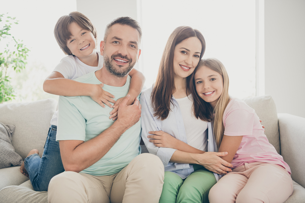 Image of parents with two kids showing their radiant smile, demonstrating the importance of general dentistry
