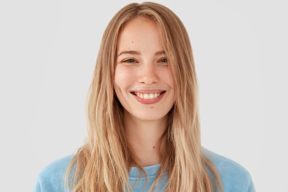 Woman smiling showing her satisfaction of crown lengthening