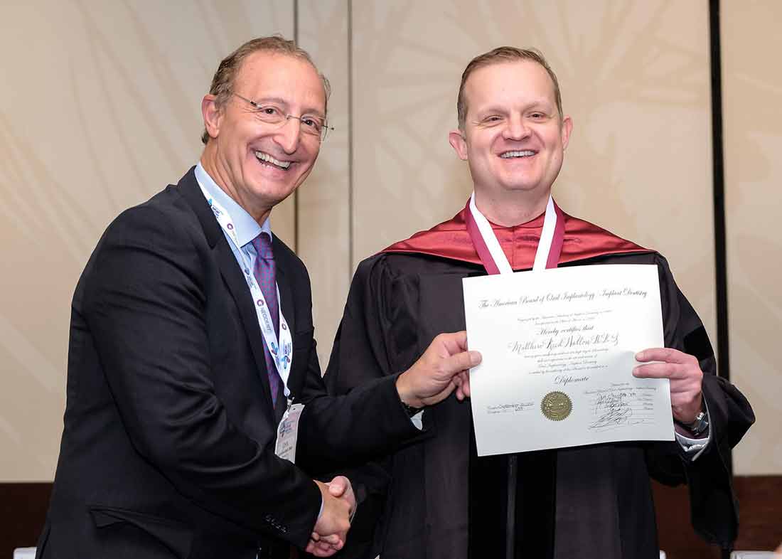 Photo of Dr. Matthew Walton receiving his American Board of Oral Implantology diploma