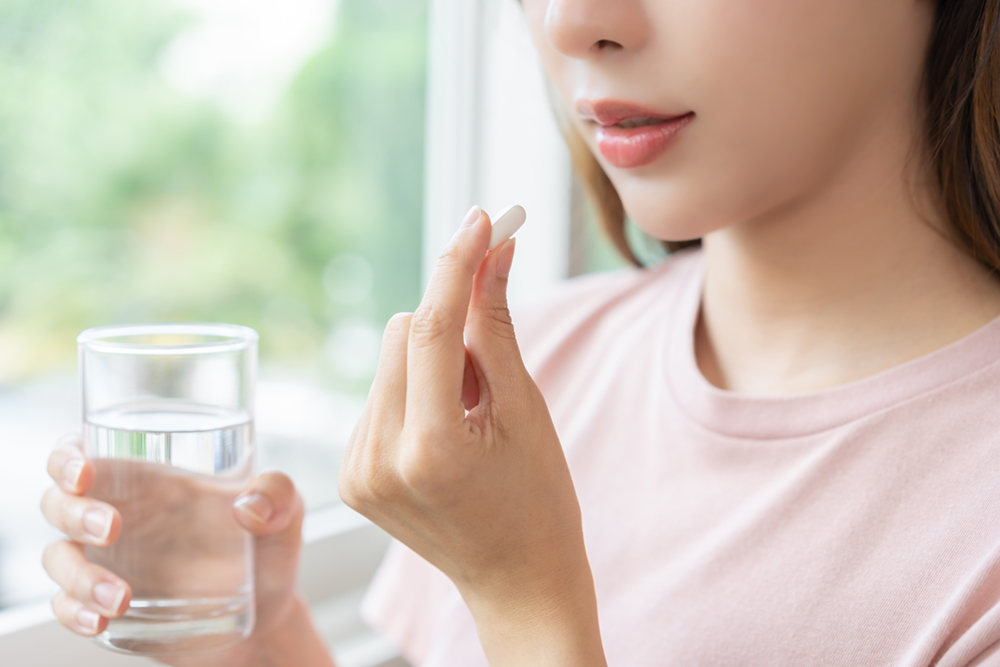 Woman taking an oral sedation pill as part of dental procedure